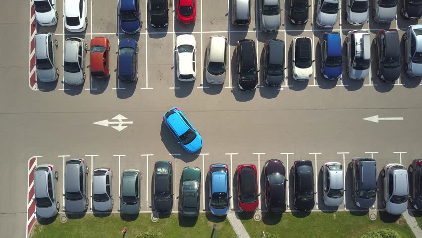 AERIAL TOP DOWN: Flying above bad driver incapable to park a car on parking space in crowded parking lot. Driver having problems, unable to park a car in parking spot. Parking fail on parkspace Royalty-Free Stock Footage #30572239