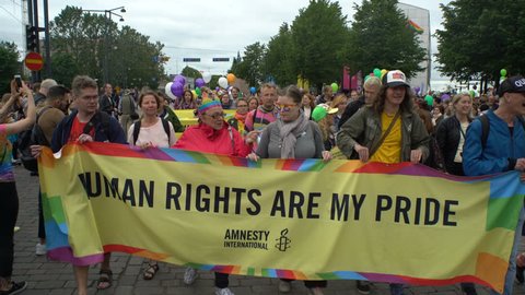 HELSINKI, FINLAND - JULY 01, 2017: Large rainbow banner about human rights during the gay parade. Thousands of people in solidarity during a Gay pride parade on the streets of Helsinki.