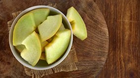 Portion of fresh made Honeydew Melon on a wooden plate (not loopable; 4K)
