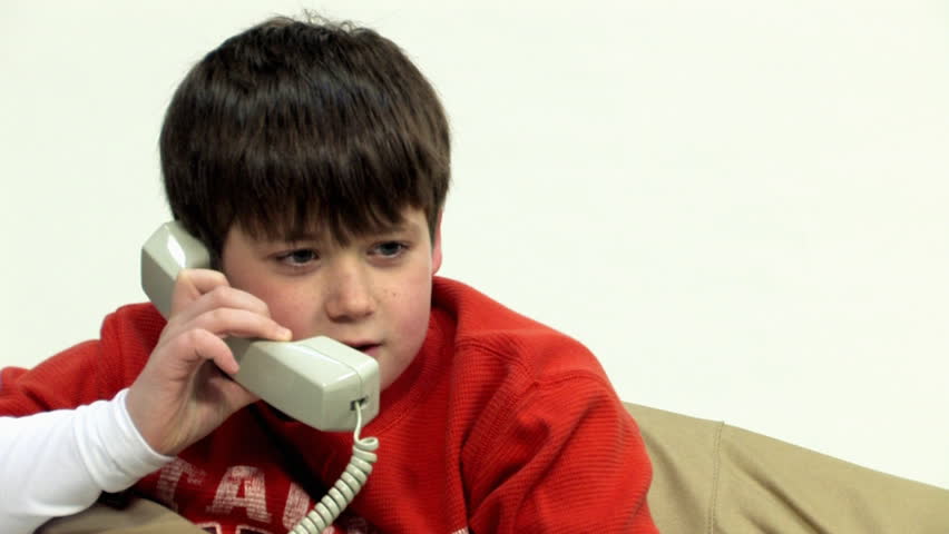 A young boy talks on the telephone.