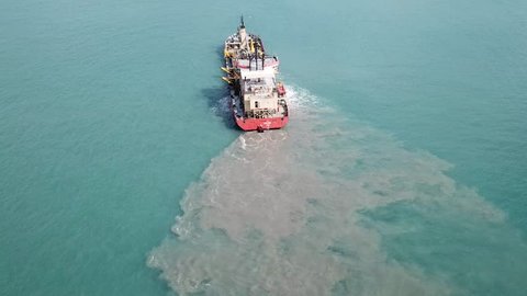 Haifa, Israe - 9 September, 2017: EDT SIMI Suction Dredger ship working near the port - with mud, Pollution, brown Muddy water - aerial shot