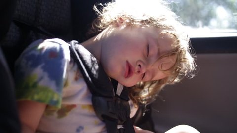 Cute Curly Haired Boy Sleeps In His Car Seat (Slow Motion Closeup)