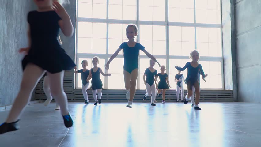 Children from ballet school run in embraces of the teacher of the ballerina. Little girls of the ballerina run to embrace the teacher. Beautiful and stately ballet teacher in the classroom teaches Royalty-Free Stock Footage #30582268