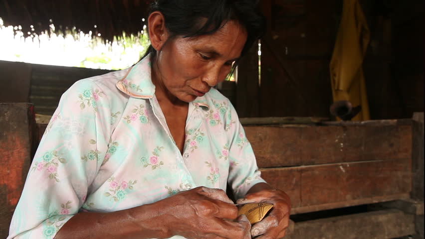 Adult woman making pottery , rural scene in ecuadorian Amazonia, finishing
