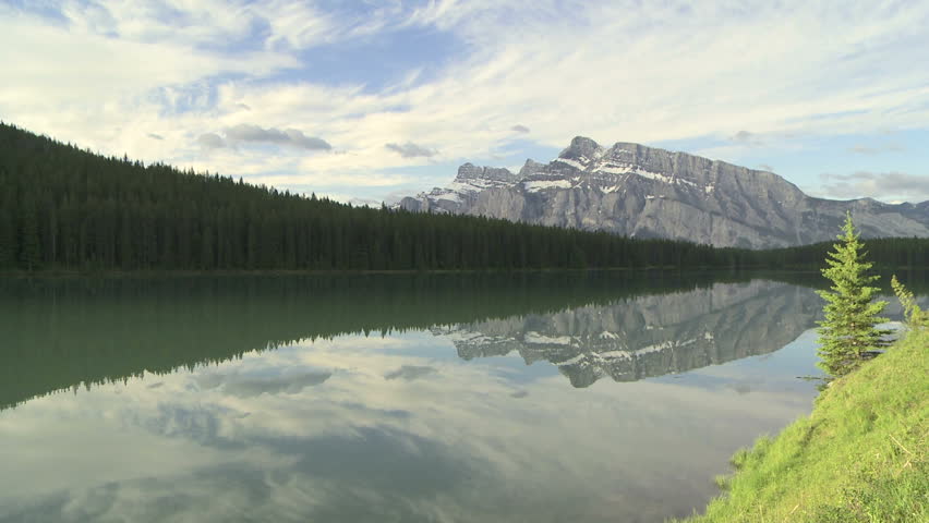 Wide shot of mountain reflection in alpine lake. Mount Rundle and Two Jack Lake