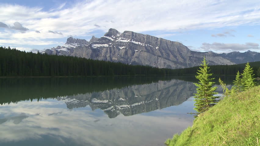 Tilt down to mountain reflection in alpine lake. Mount Rundle and Two Jack Lake
