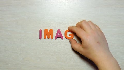 The video shows the word "image" made up of plastic colored letters on a wooden background.