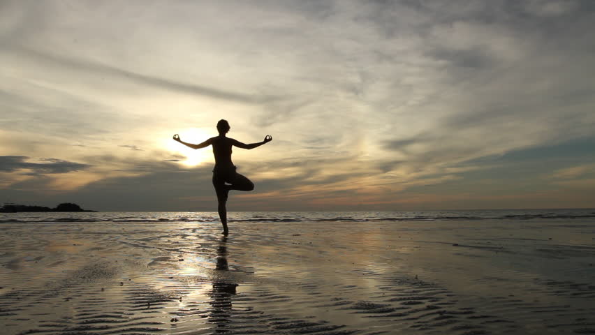 Young woman practicing yoga on the beach at sunset (HD)