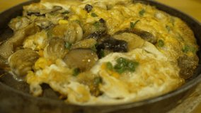 Fried clams with omelet in dish thai food (loopable video). Close up and select focus. 4k uhd