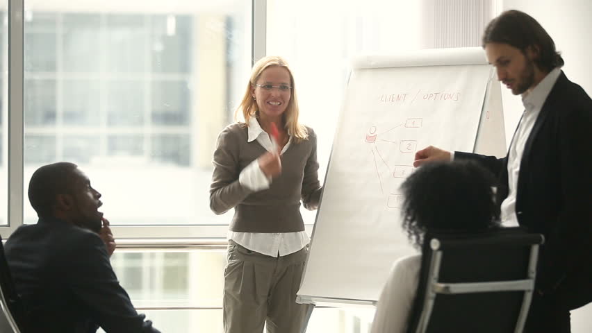 Businesswoman and businessman giving presentation using flipchart, business coaches teaching african black sales managers on staff training, female team leader explaining new company strategy Royalty-Free Stock Footage #30610972