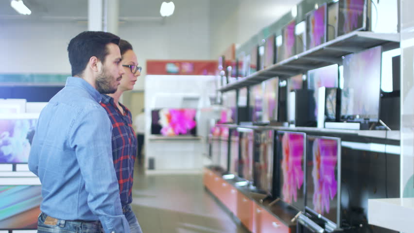 Young Couple Shopping for a New 4K UHD Television Set in the Electronics Store. They're Deciding on the Best Model for Their Happy Family House. Shot on RED EPIC-W 8K Helium Cinema Camera. Royalty-Free Stock Footage #30615007