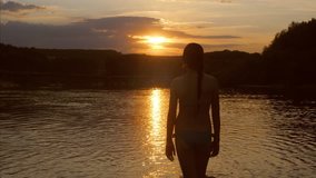 young girl walking on water at sunset, Slow motion