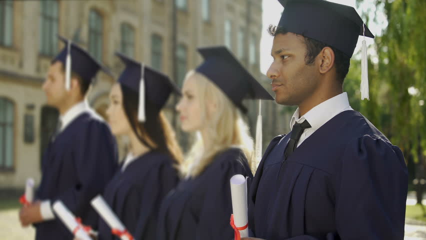 Mixed-race graduate student with diploma smiling into camera, exchange program