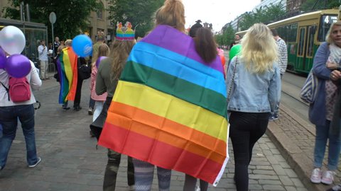 HELSINKI, FINLAND - JULY 01, 2017: Young women with rainbow flags. Thousands of people in solidarity during a Gay pride parade on the streets of Helsinki.