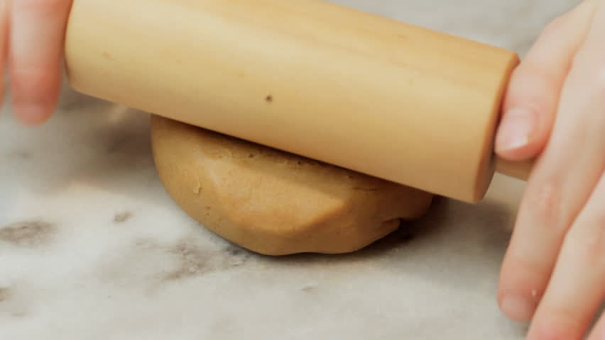 Little girl rolling cookie dough CU