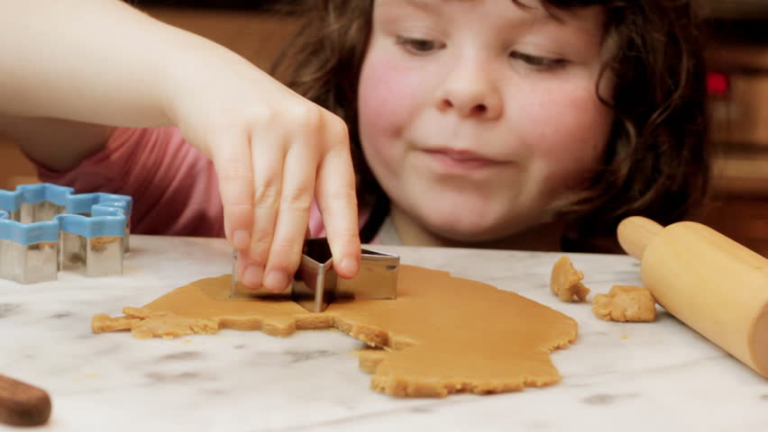 Little girl cutting gingerbread