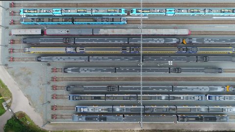 Aerial moving right above railway hub showing passenger trains on tracks next to each other top down view drone moving slowly showing railway tracks positioned horizontally above each other 4k quality