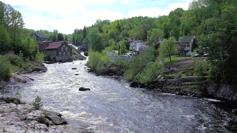Chicoutimi, Canada - June 3, 2017: La Pulperie de Chicoutimi Regional Museum Pulp mill in Saguenay, Quebec with river and water flowing in summer