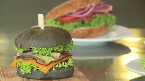 Concept of finishing cooking a black burger Burger with black buns. Sliced vegetables and meat. Taste the best hamburger