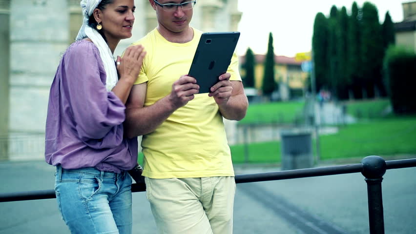 Tourists on city trip using tablet computer for sightseeing
