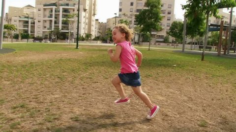 Little Girl running at playground / park in slow motion. Sequence. Stock Video