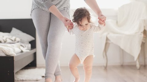 Baby taking first steps with mother help