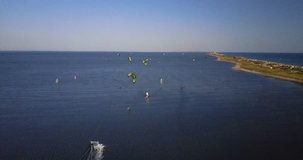 kite surfing in the sea along the sand spit on the green sail aerial video on top
