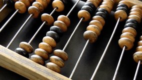 Video shows old wooden abacus. Man is making a calculation