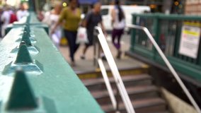 People descend staircase to NYC underground subway station during day time rush hour commute. Defocus blur slow motion HD stock video