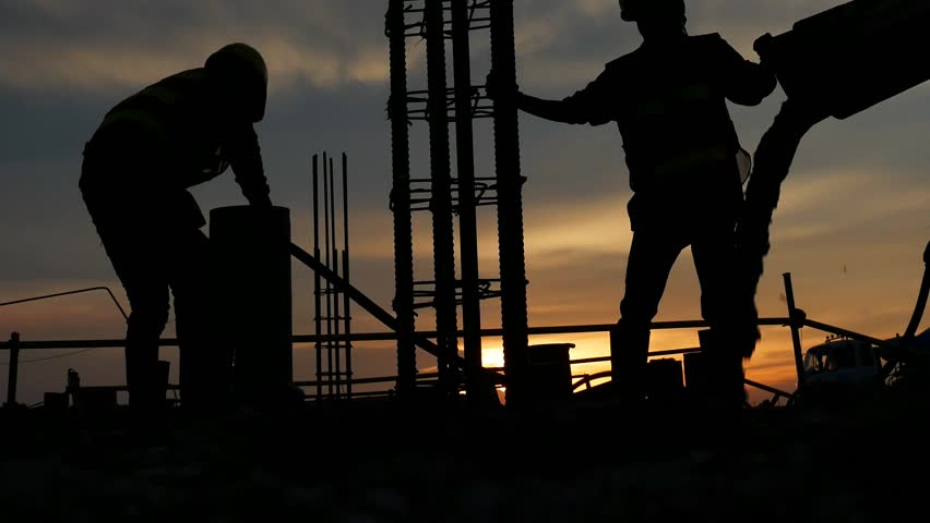 Silhouette the group of workers working at a construction site.Construction workers work in preparation for binding rebar and concrete work