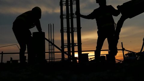 silhouette the group of workers working at a construction site.Construction workers work in preparation for binding rebar and concrete work