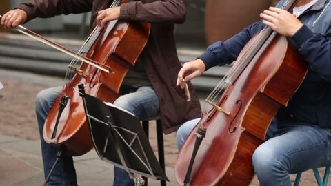 A group of musicians playing cellos on a street in a European city Video Stok
