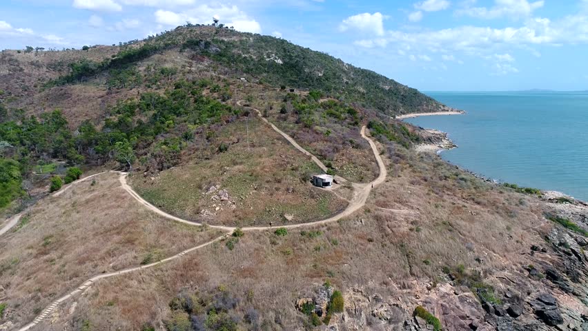 4K Aerial Footage pan towards coastal mountain beach cliff with war bunker - Townsville Queensland Australia - forward pan