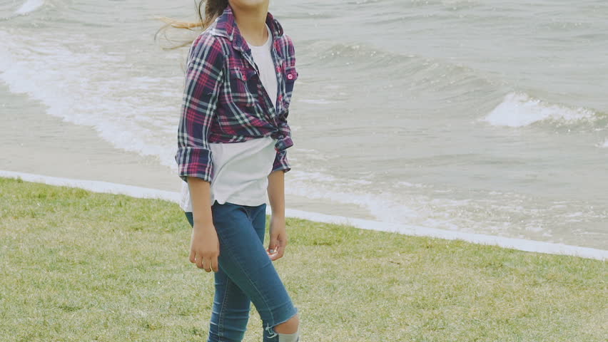 Portrait of happy carefree young girl posing with hair on windy day . Slowly