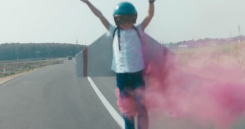 Little boy wearing helmet and styrofoam wings standing on a rural road, pretending to be a pilot. 4K UHD RAW edited footage