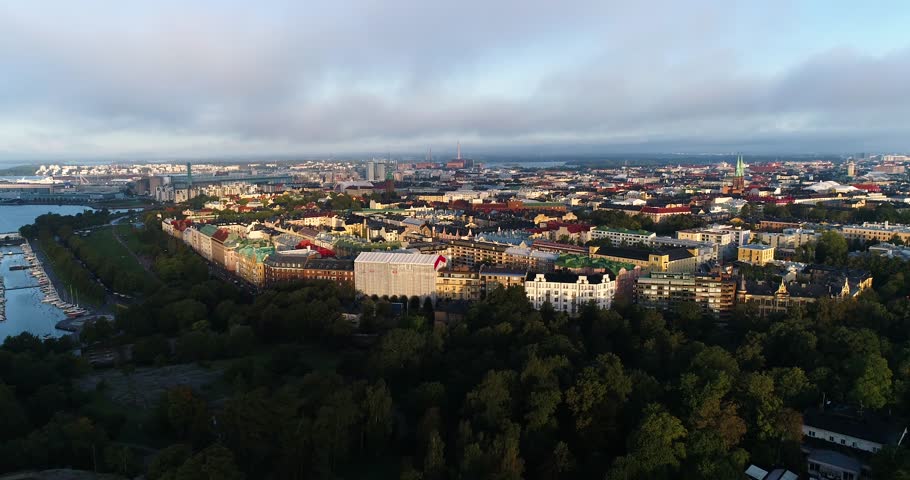 Aerial view of Helsinki capital of Finland. Drone flying forward above straight street line during sunny summer morning city filming old buildings and lots of colorful rooftops. Eira. Ullanlinna.