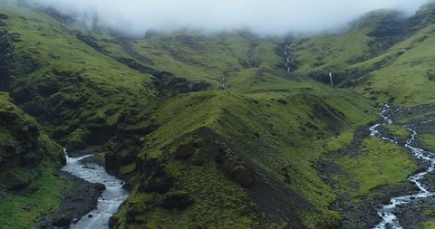 Exotic aerial of foggy green mountains and rivers in Iceland