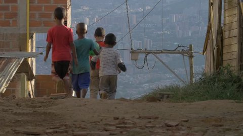 MEDELLIN, COLOMBIA - JULY 2017: POOR KIDS WALK DOWN AN ALLEY (BRINGING A FOOTBALL) 4K