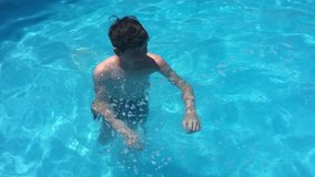 kids bathe in the pool. children boy and girl swimming water in the pool playing slow motion video