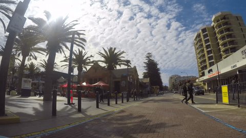 ADELAIDE, SOUTH AUSTRALIA - OCTOBER 2, 2016: Vehicle point of view driving along Jetty Road to Moseley Square in Glenelg, a seaside and tourism suburb of Adelaide, South Australia, with lens flare. 