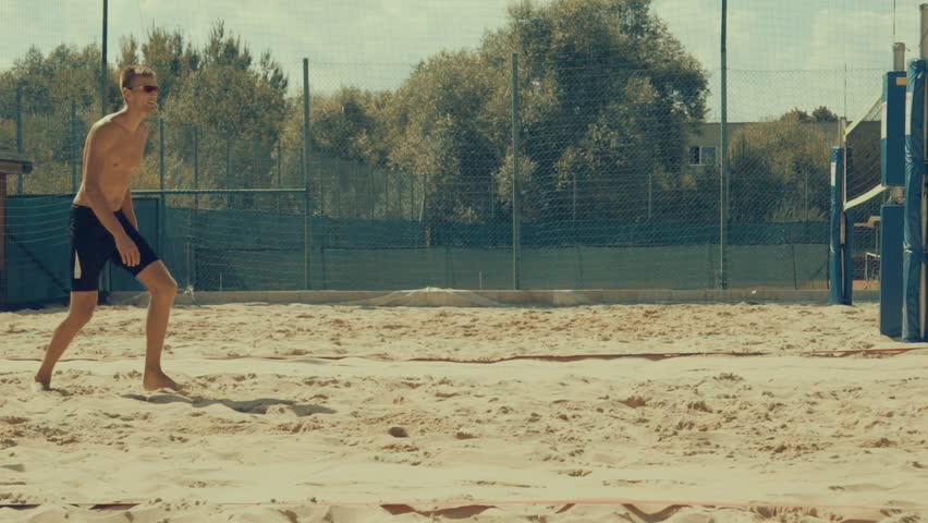 Beach volleyball players in action at sunny day under blue sky. Slow motion 