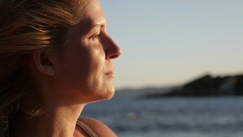 Caucasian woman enjoying by the sea before sunset 4K 2160p 30fps UltraHD footage - Close-up of blond female on the beach 3840X2160 UHD video