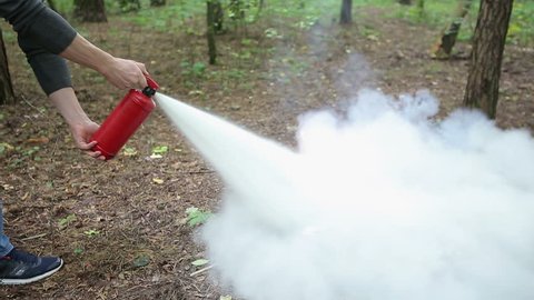 Man using fire extinguisher.Extinguishing open fire with a powder fire extinguisher.