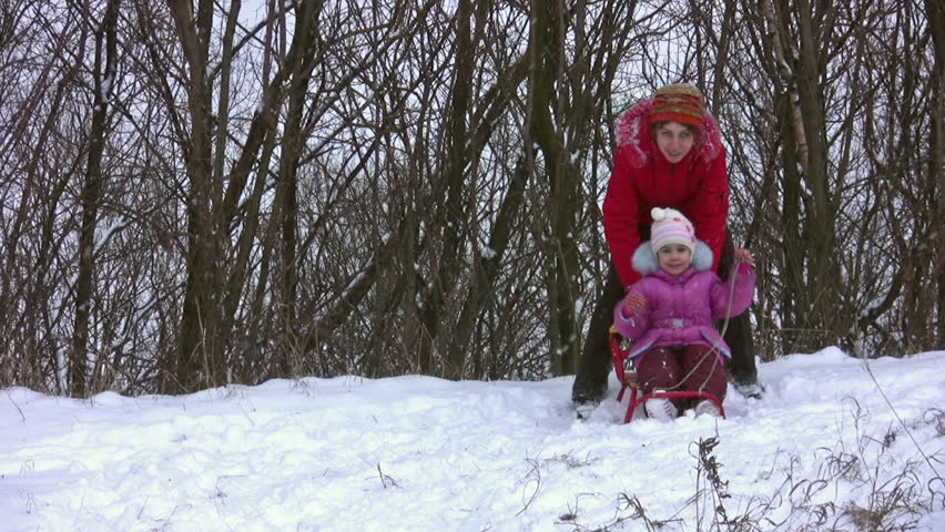 woman with little girl on sled 