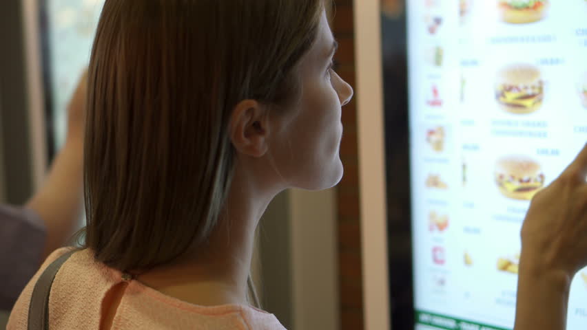 Beautiful attractive woman in food court mall. Ordering food via self-service machine at fast-food chain restaurant Royalty-Free Stock Footage #30756082
