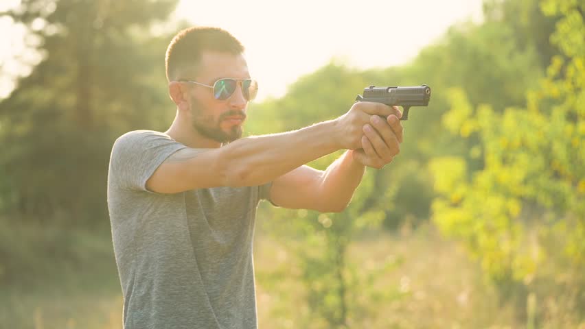 Young man is shooting from a gun, close up. Slow motion | Shutterstock HD Video #30761899