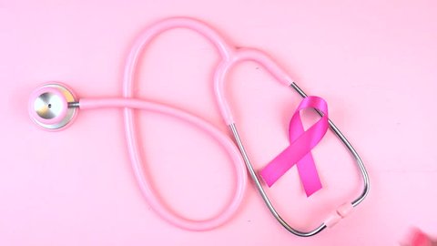 Pink Ribbon charity for Breast Cancer Awareness month in October, placing pink ribbon on stethoscope. 