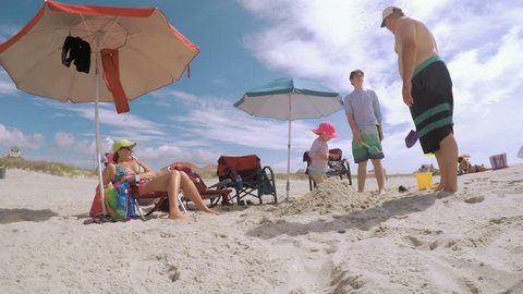 Myrtle Beach, South Carolina, USA-July 11, 2017.  POV point of view - Summer vacation on the beach. Father and kids playing in the sand.