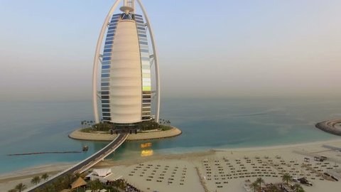 DUBAI, United Arab Emirates, August 17, 2017. Aerial. Camera moves up
 Burj Al Arab, the most famous hotel in the world. Sunrise. 4K 

