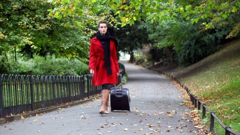 fashionable lady walking in the park with luggage  Stock Video